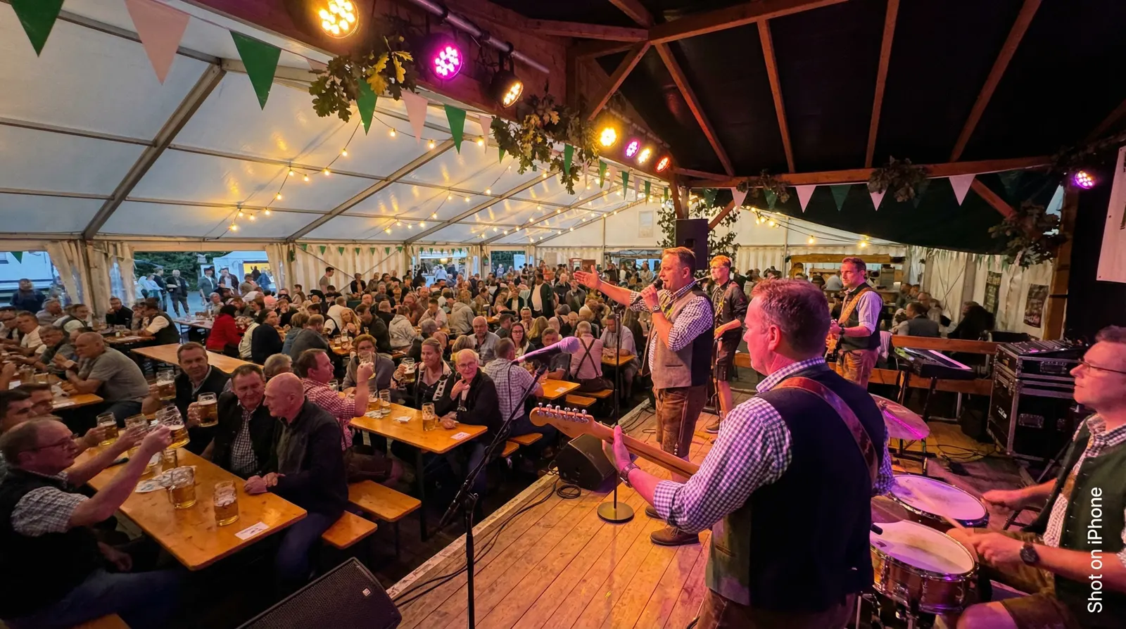 Live-Band auf einem Schützenfest – Musiker auf der Bühne im festlich geschmückten Bierzelt
